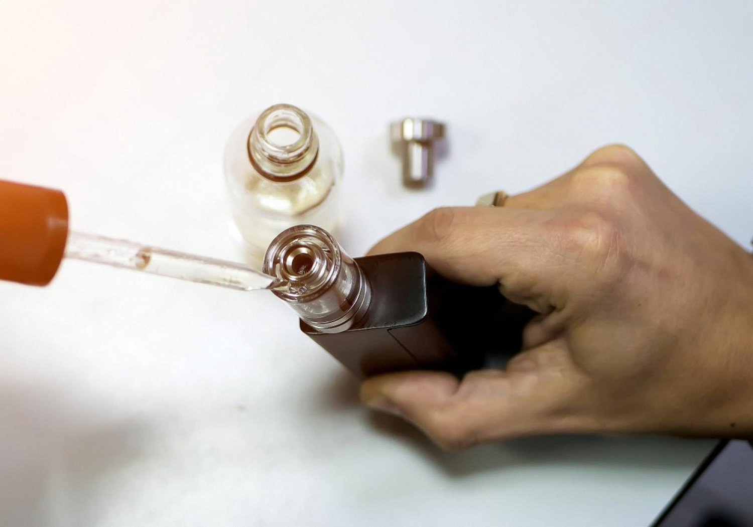 Refilling a nicotine device with liquid, showing an alternative to cigarettes